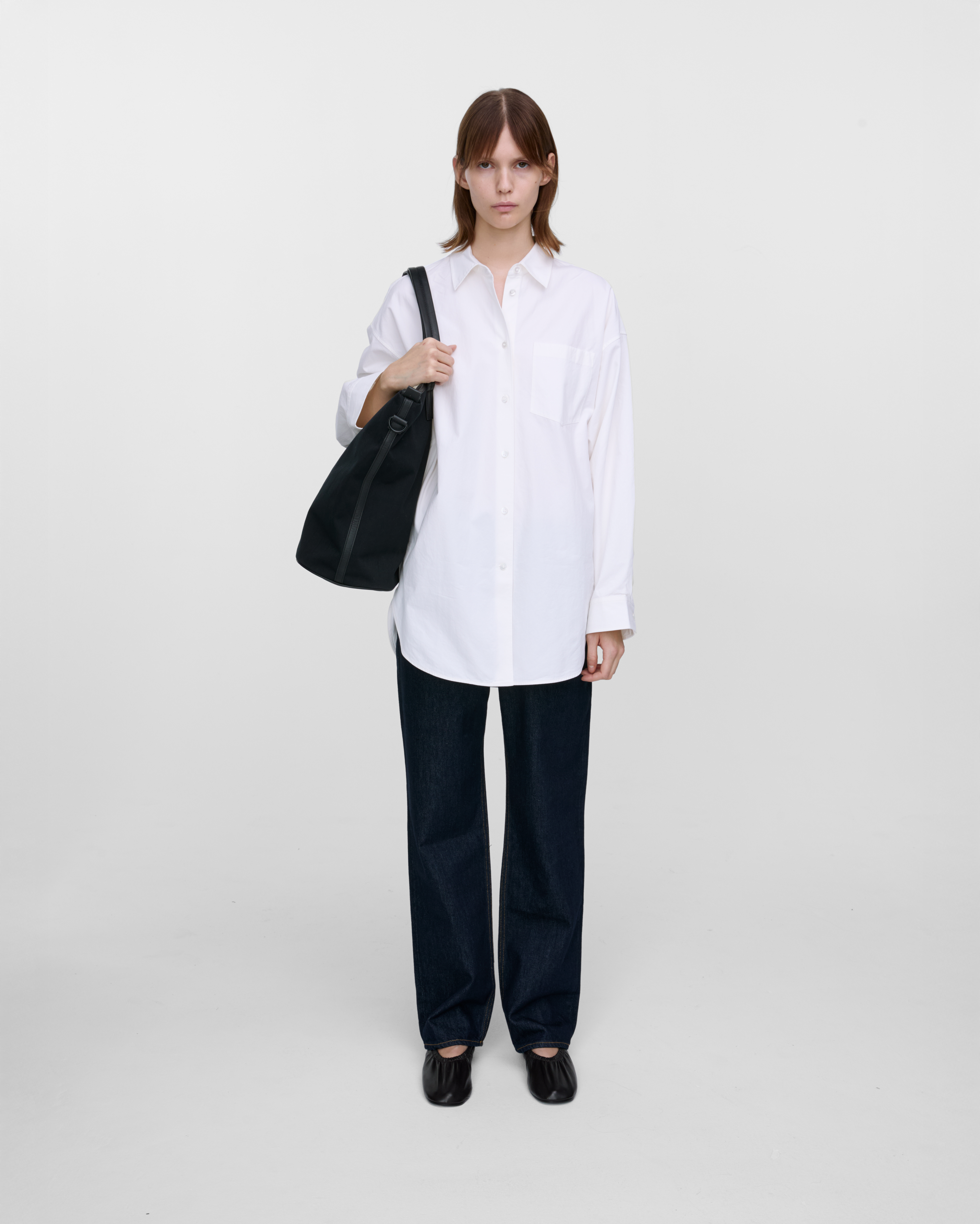 Female model wearing Sandqvist Everyday Weekend Bag, black. Front view, wearing the bag on one shoulder.