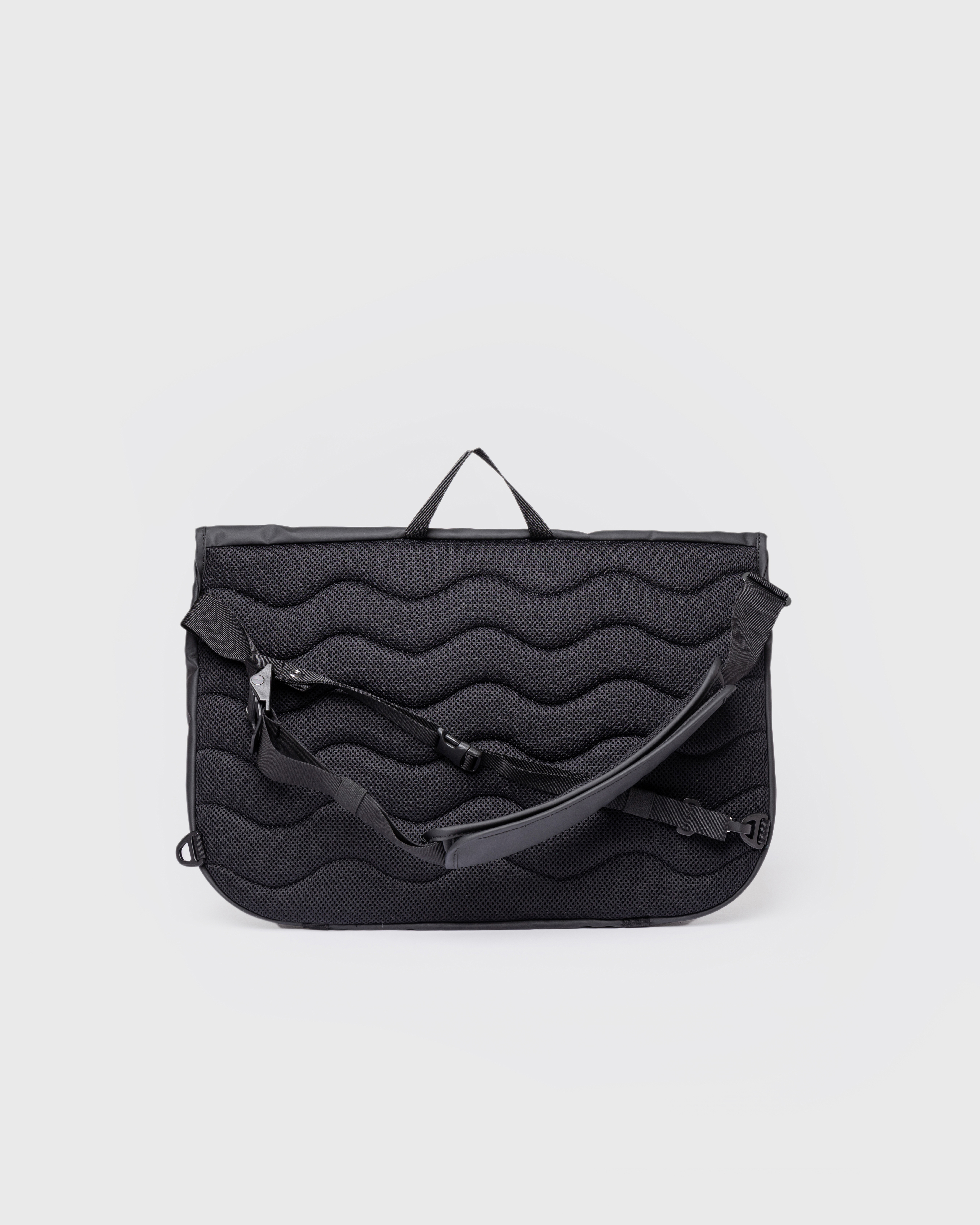 Messenger bag. Sandqvist STREAM Messenger Bag in black, back view with padded back panel, adjustable shoulder strap and chest strap.