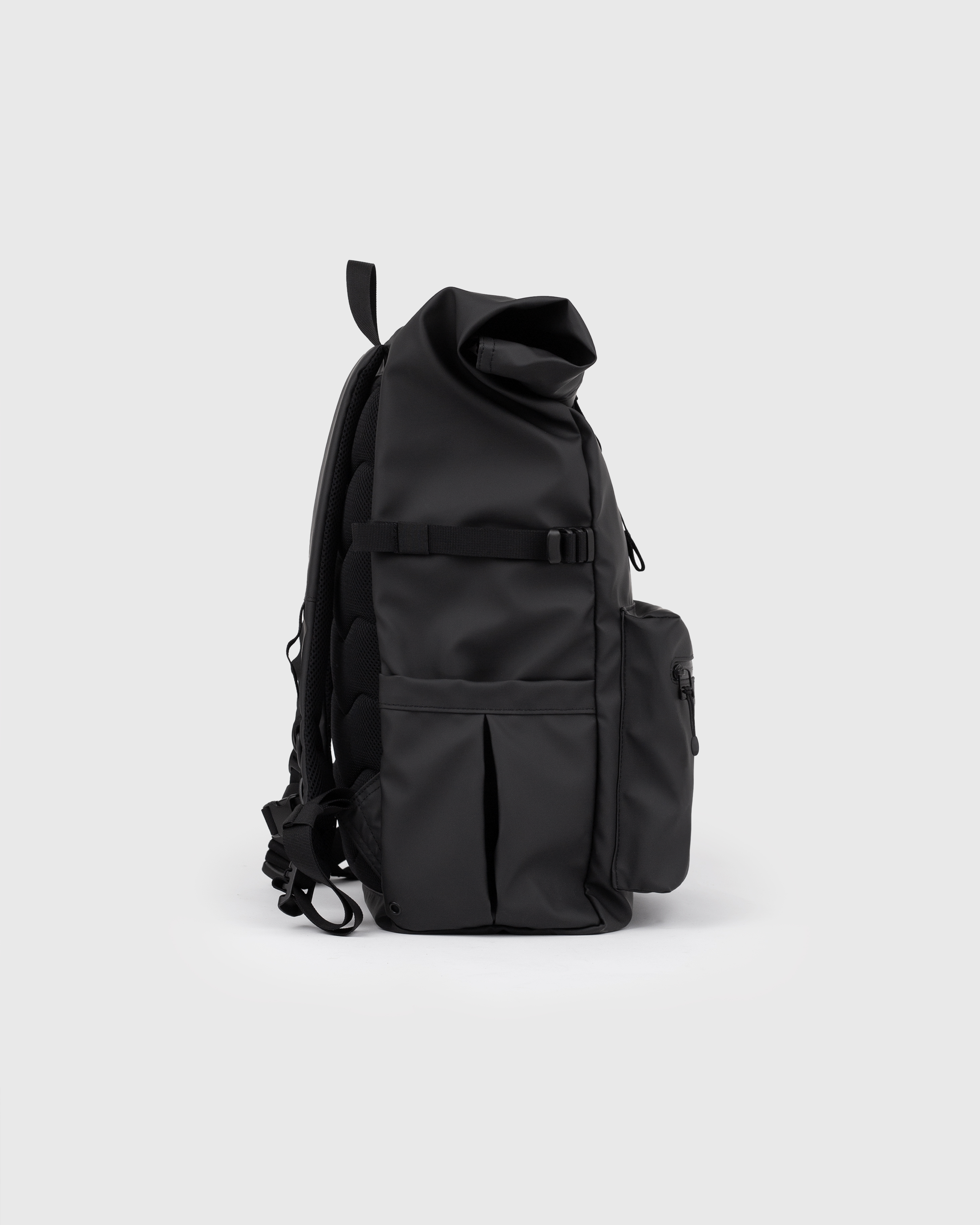 Backpack. Sandqvist STREAM Rolltop backpack L in black, side view with, top handle, pocket at front, slip pocket, side strap and rolltop closure.