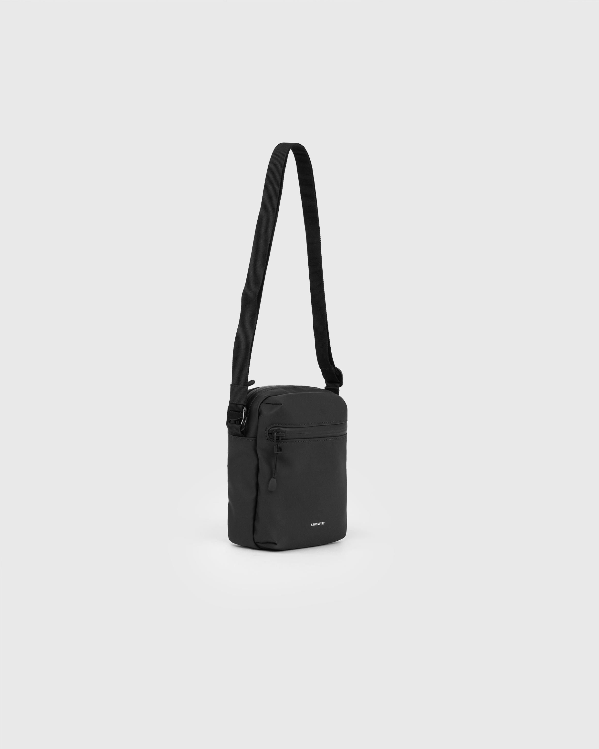 Sandqvist STREAM Shoulder Bag in black, side view with front zipper pocket, adjustable shoulder strap and main compartment with zipper.