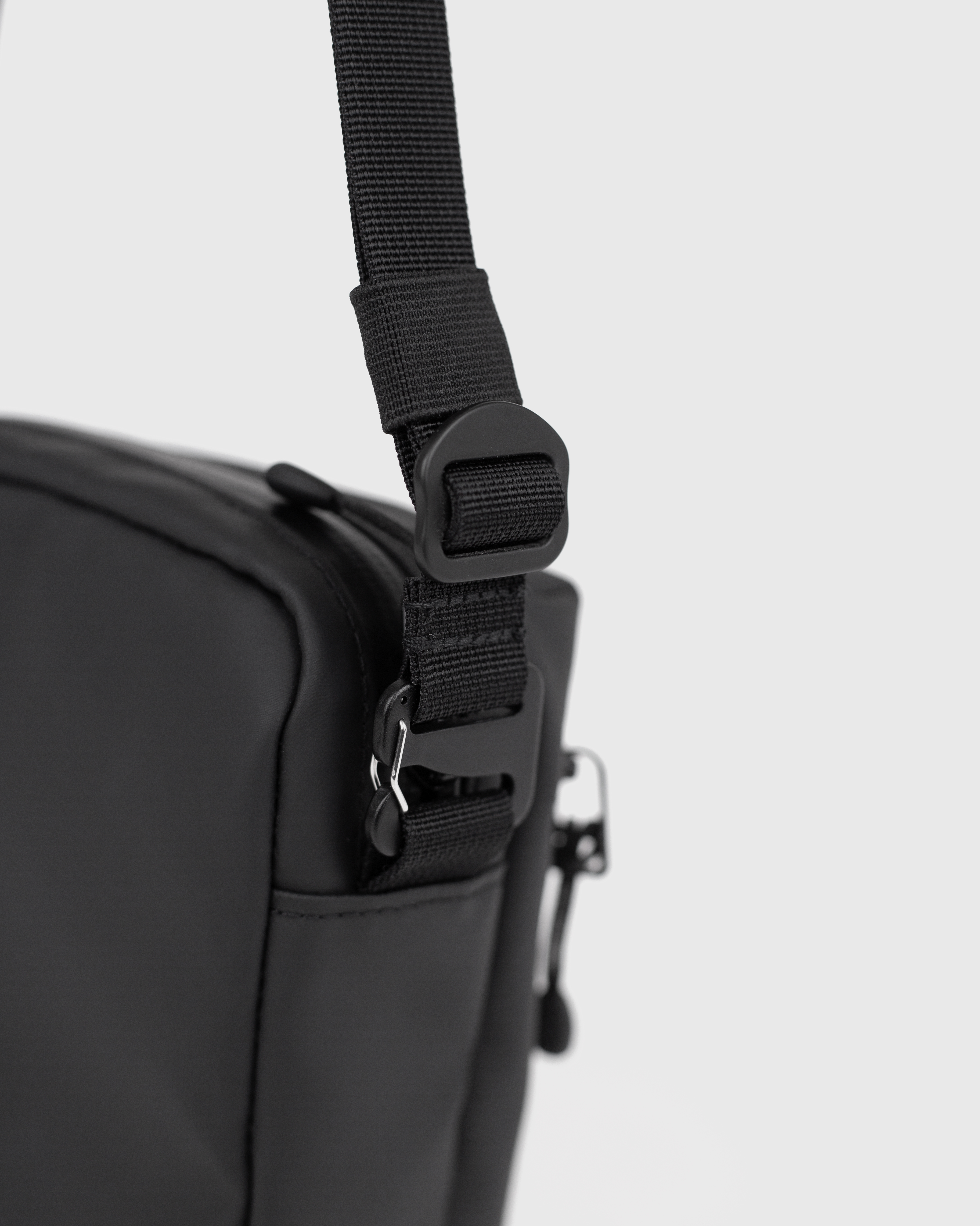 Sandqvist STREAM Shoulder Bag in black, close up of buckle and adjustable shoulder strap.