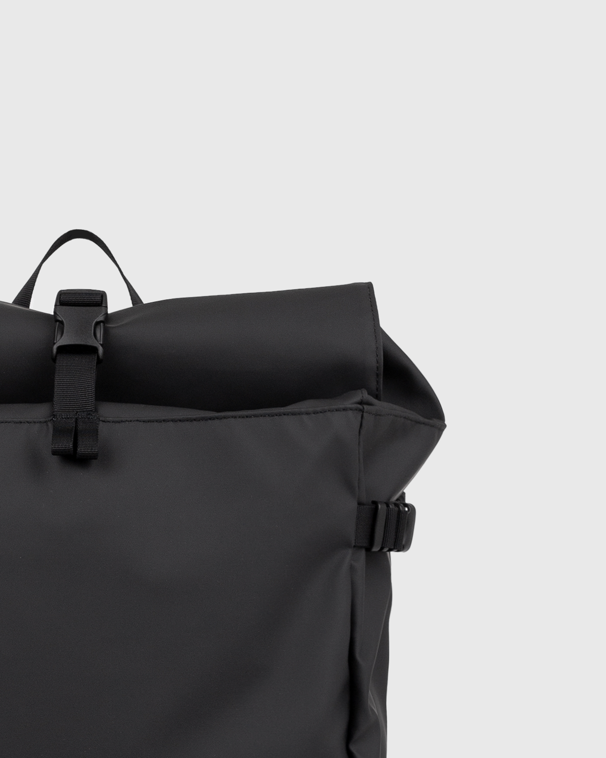 Sandqvist STREAM Slim Rolltop L backpack in black, close up view on rolltop closure.