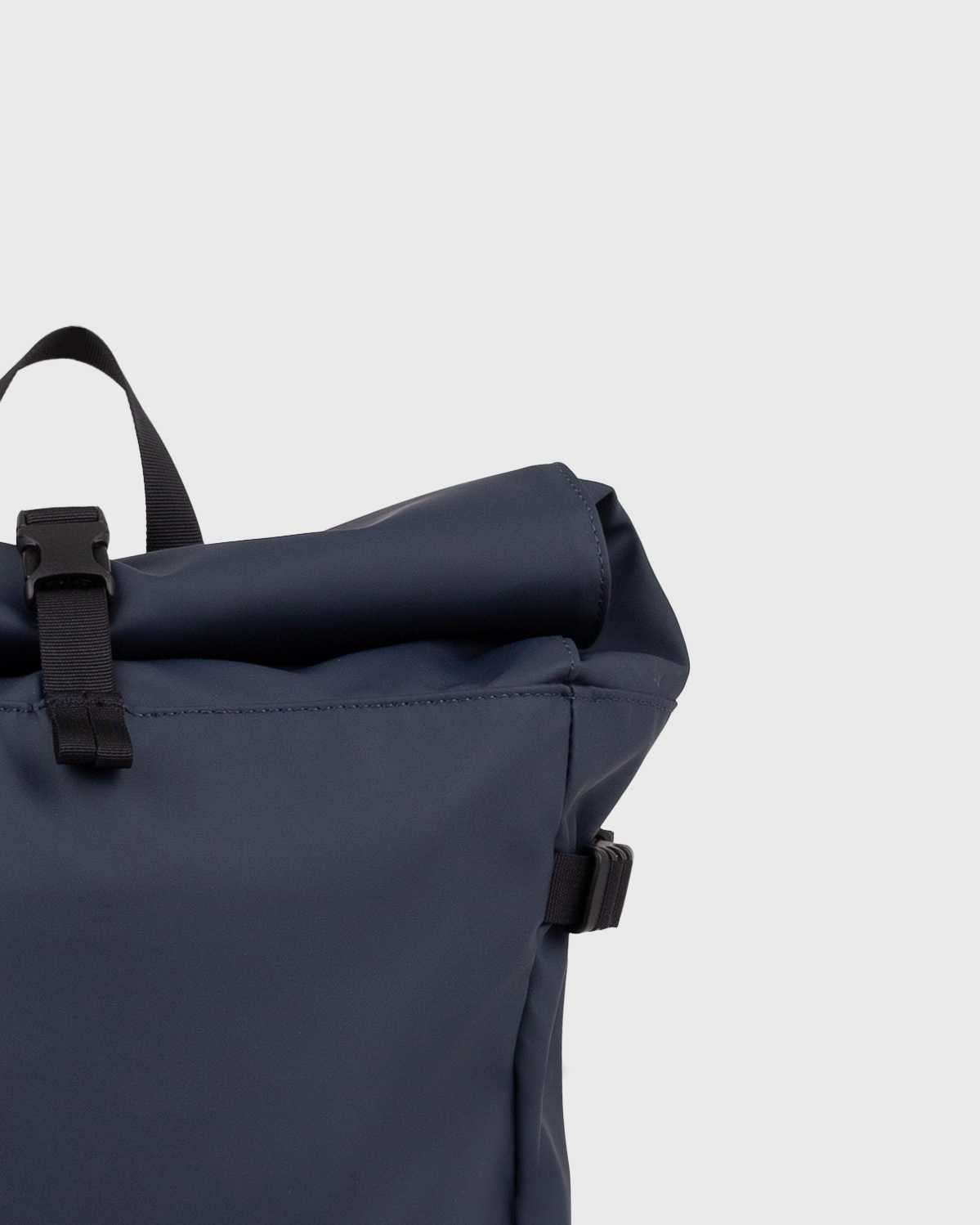 Sac à dos Sandqvist STREAM Slim Rolltop L en bleu marine, gros plan sur la fermeture à enroulement.