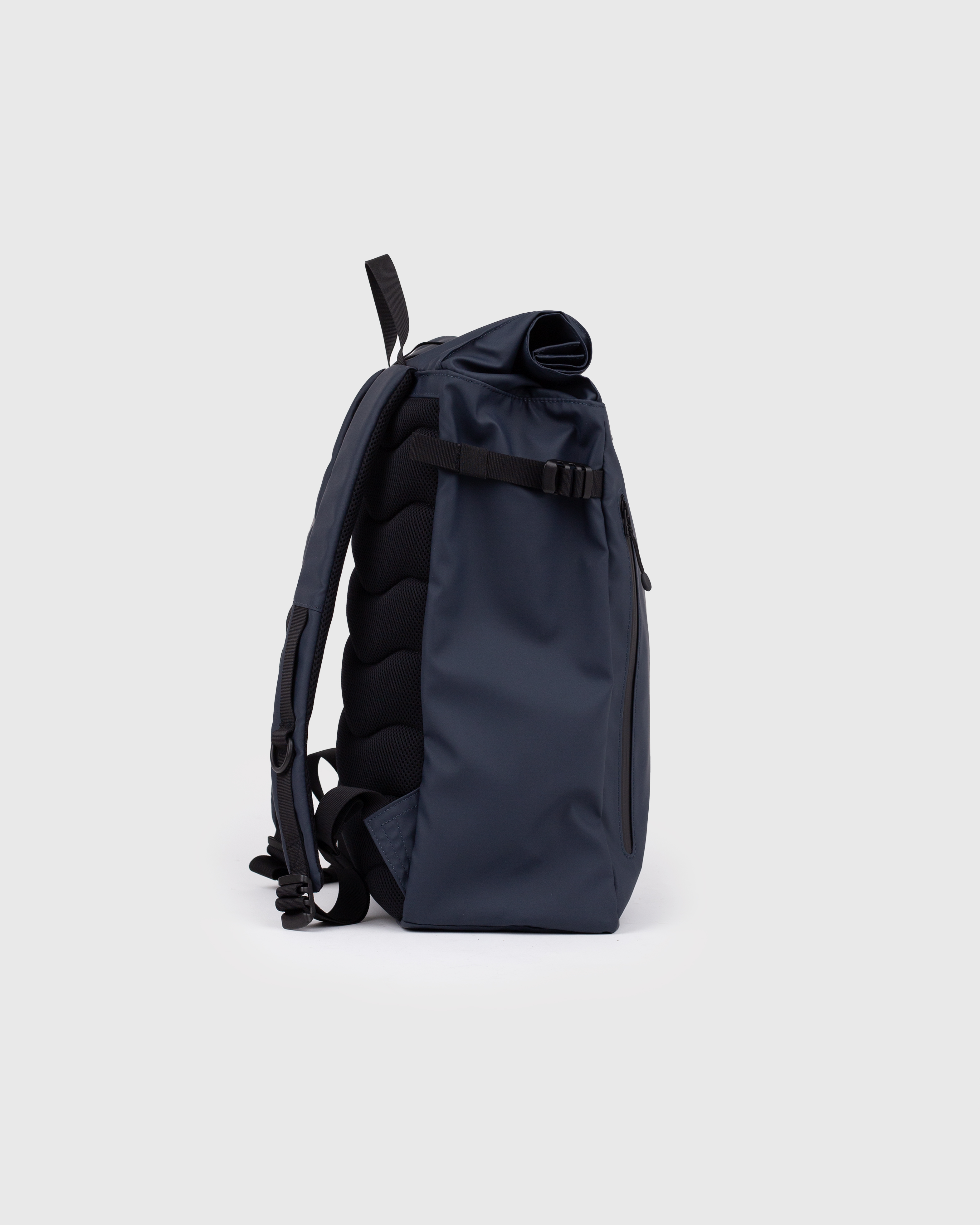 Sac à dos Sandqvist STREAM Slim Rolltop L bleu marine, vue latérale avec bandoulière, poignées supérieures et fermeture à enroulement.