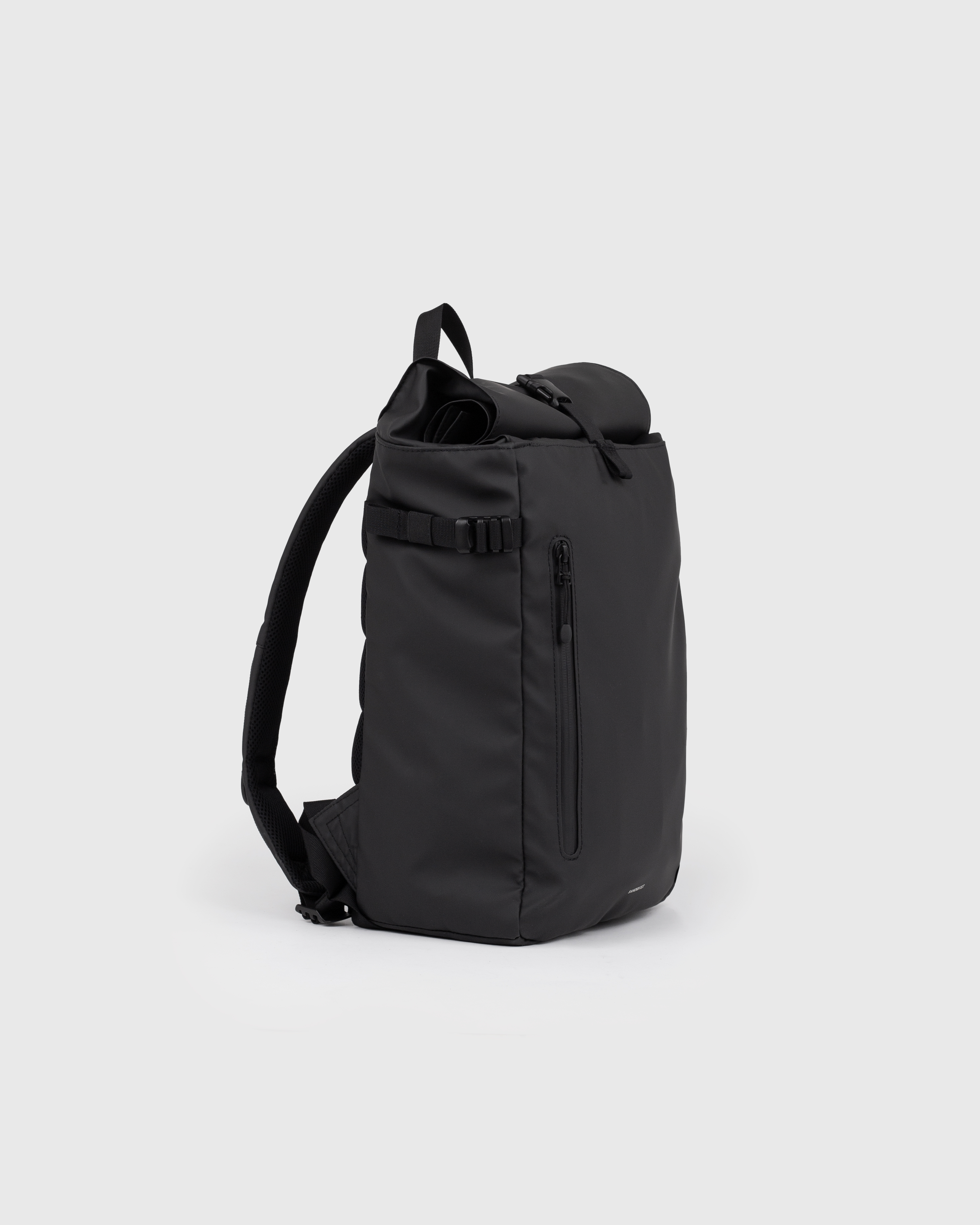 Sandqvist STREAM Slim Rolltop M backpack in black, side view with shoulder strap, top handle, zipper pocket at front and rolltop closure.