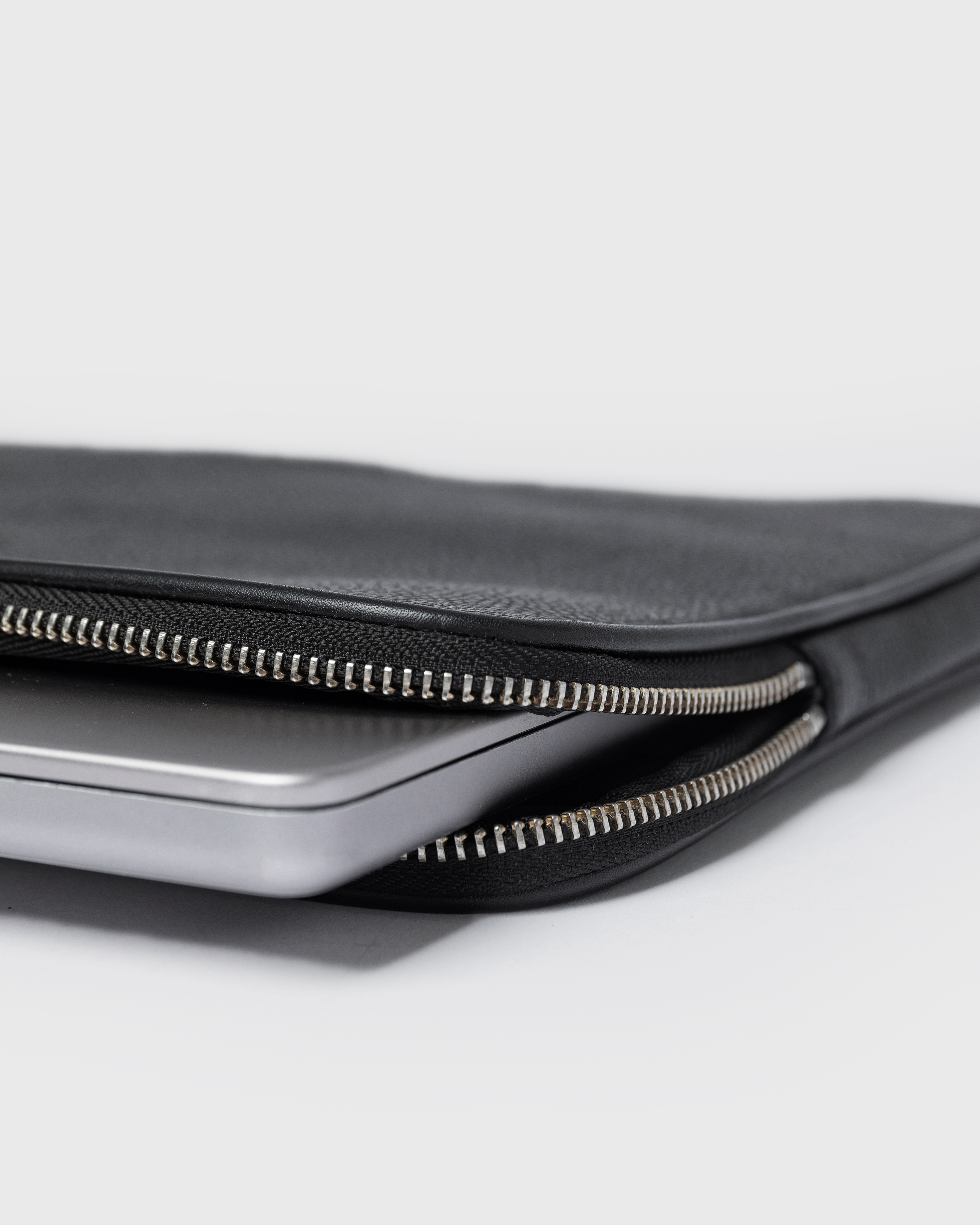 Close up view of the laptop case Sandqvist LEATHER Laptop Case 14" with opened zipper compartment and laptop inside. 