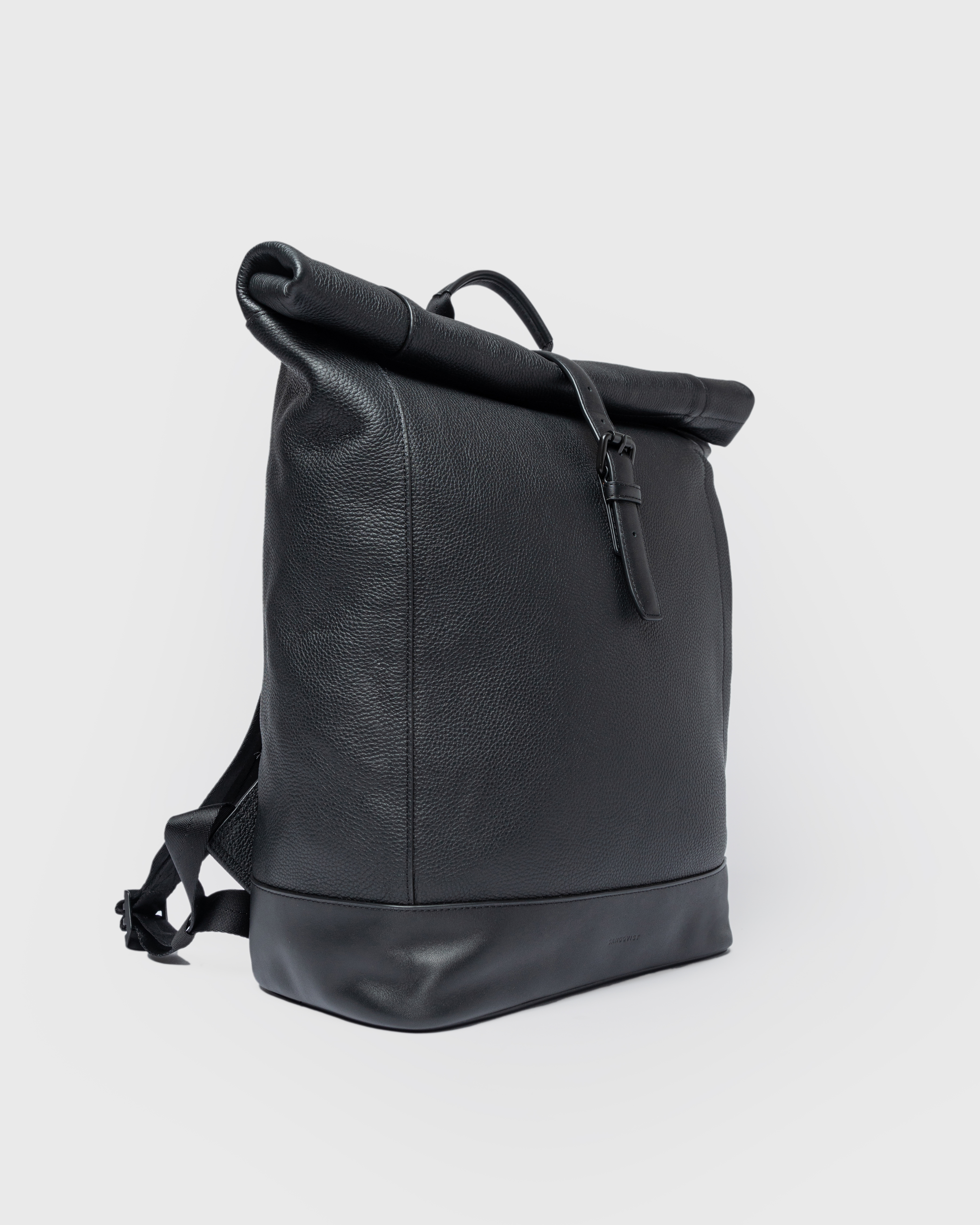 Sandqvist LEATHER Rolltop backpack in black, side view with rolltop closure and top handle.