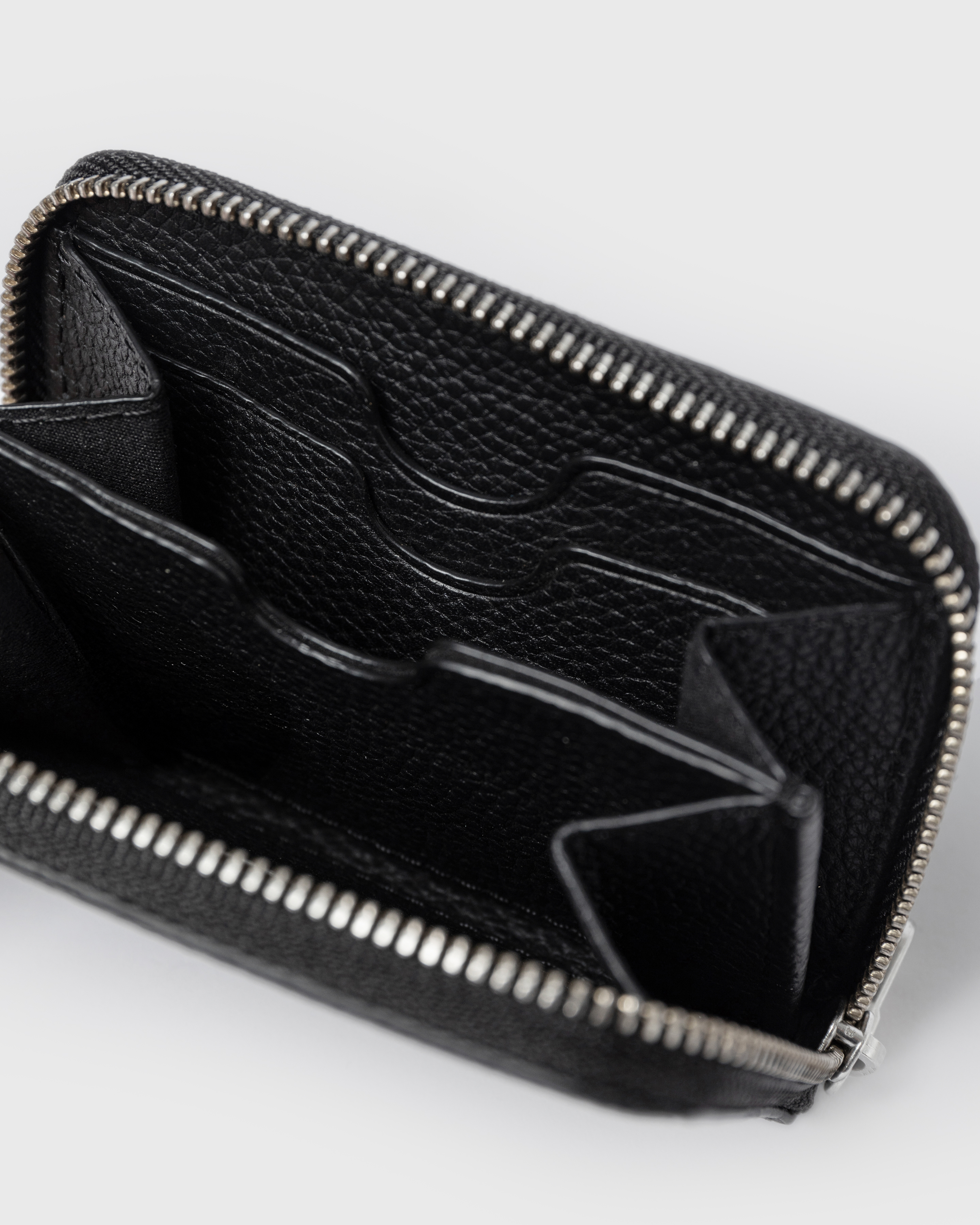 Top view of LEATHER Zip Wallet Multi Slot in black with zipper closure with three slip pockts and two bigger open pockets.