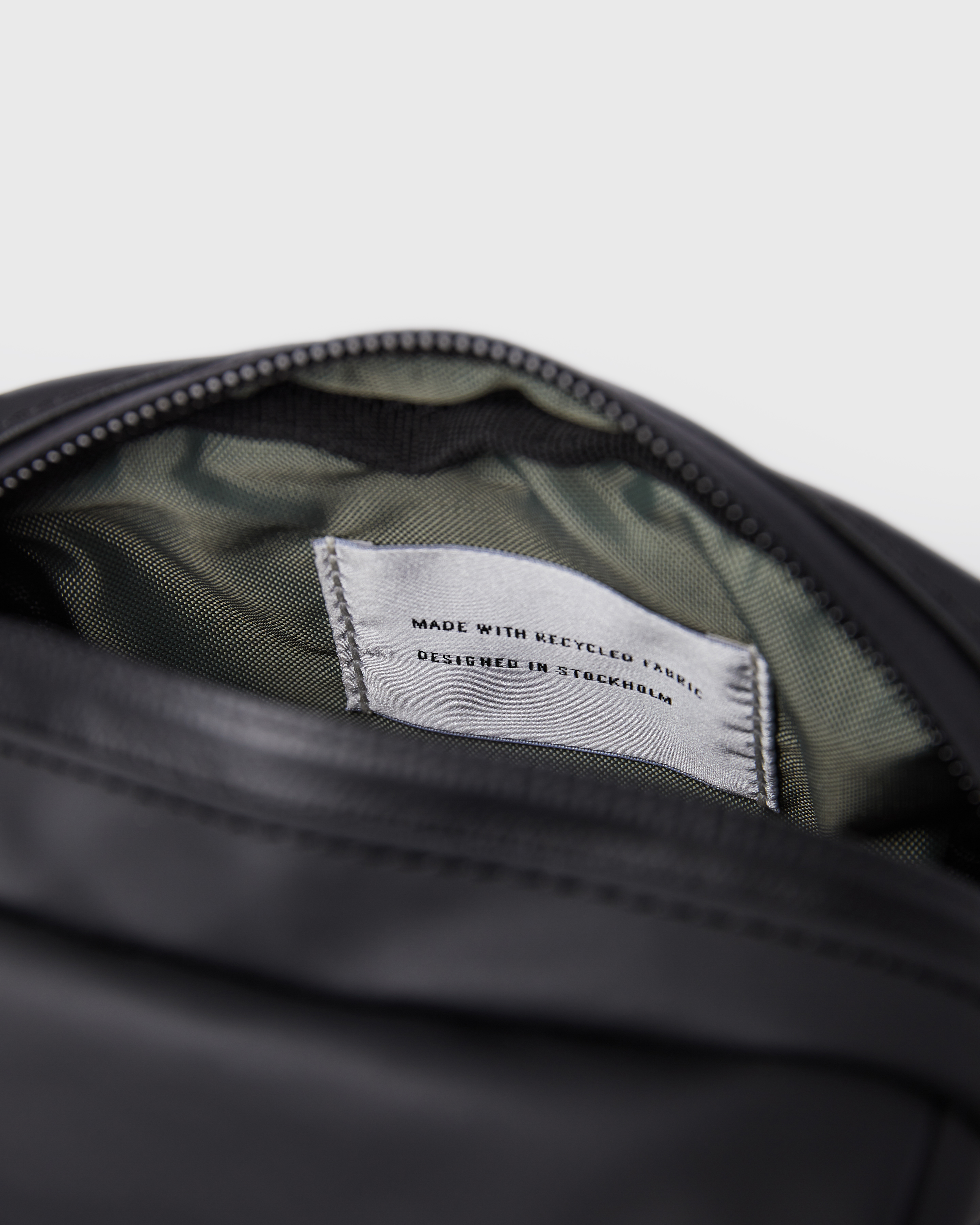 Sandqvist Shoulder bag Poe in black. Close up of open zipper main compartment. 