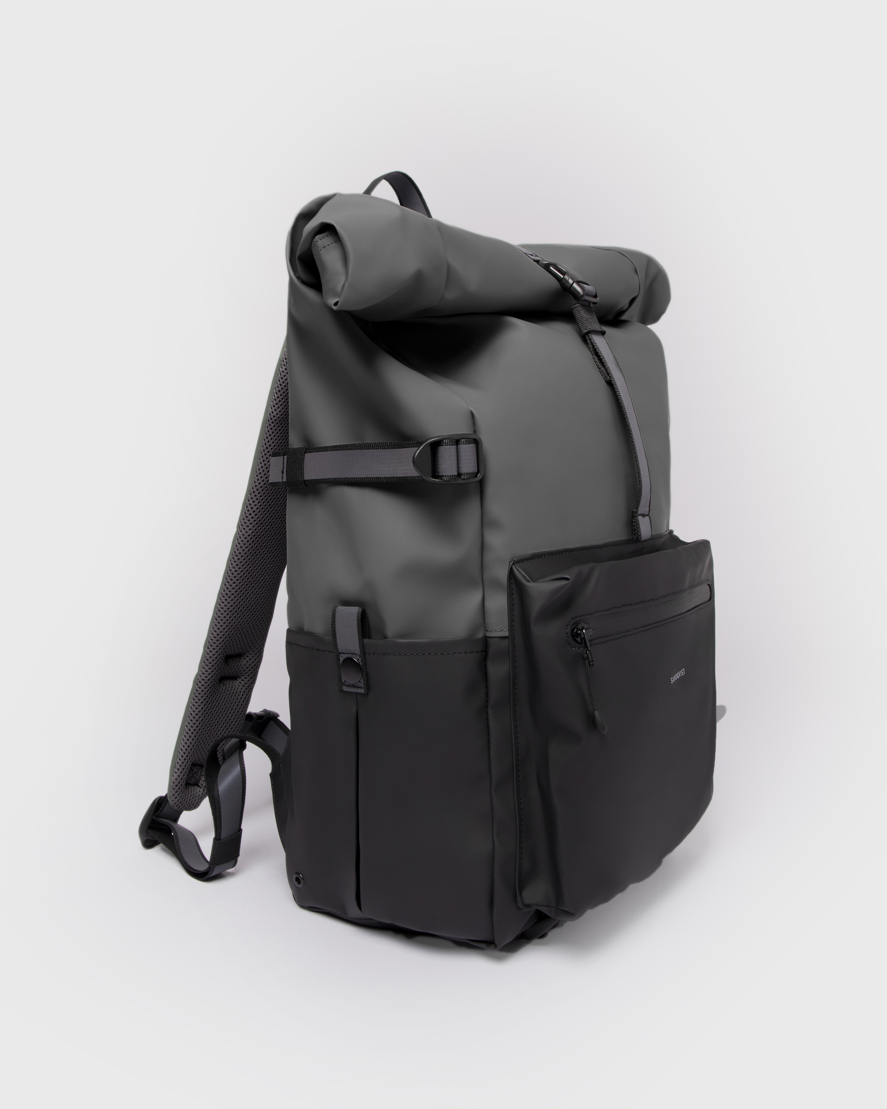 Sandqvist Backpack Ruben 2.0 in Grey and black. Side view with reflective side strap, side slip pocket, front zipper pocket and rolltop closure.