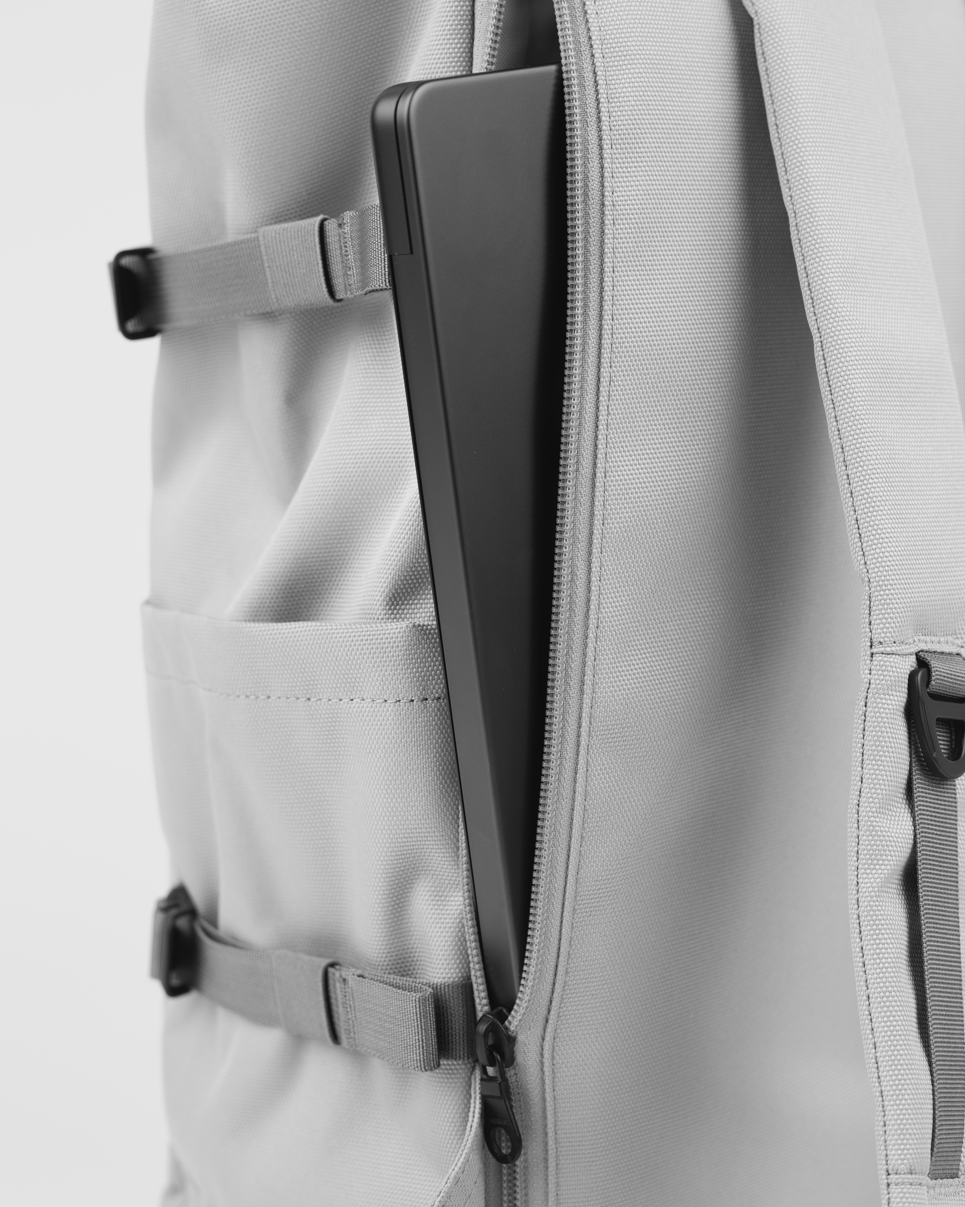 Sandqvist Icon Rolltop Backpack L 16, grey. Close-up of the outside laptop compartment with a zipper.
