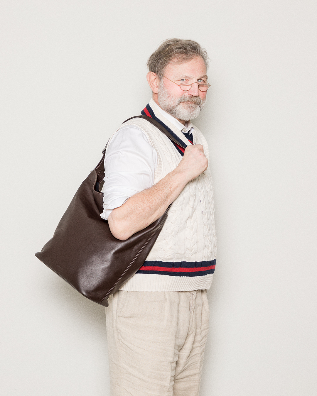 Male model wearing the Sandqvist Leather Shopper bag, dark brown. Side view, wearing the bag on one shoulder.