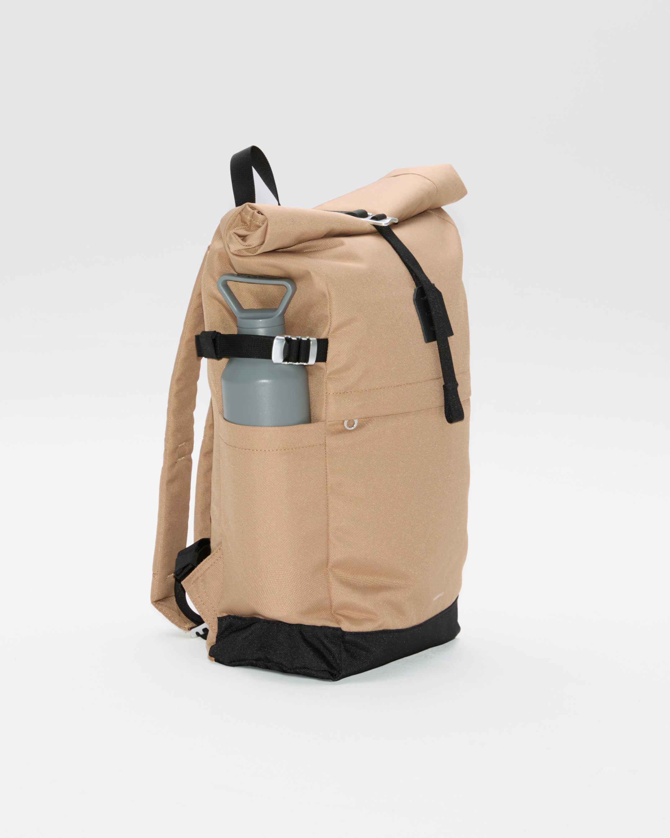 Sandqvist ICON Rolltop Backpack 14”, beige. Side view showing the side slip pocket packed with a waterbottle secured with the side strap.