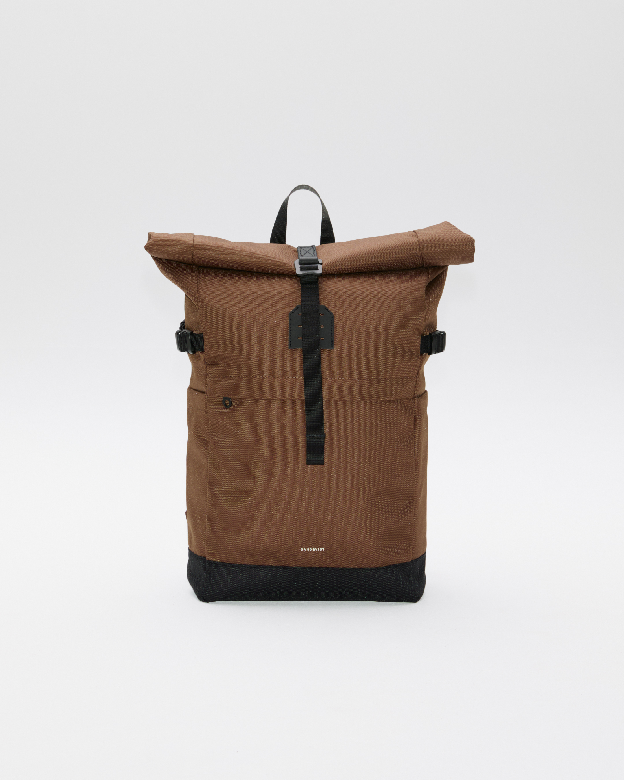 Sandqvist ICON Rolltop Backpack 14”, brown. Front view showing, rolltop closure with metal buckle, top handle, front pocket with zipper and one side strap on each side.