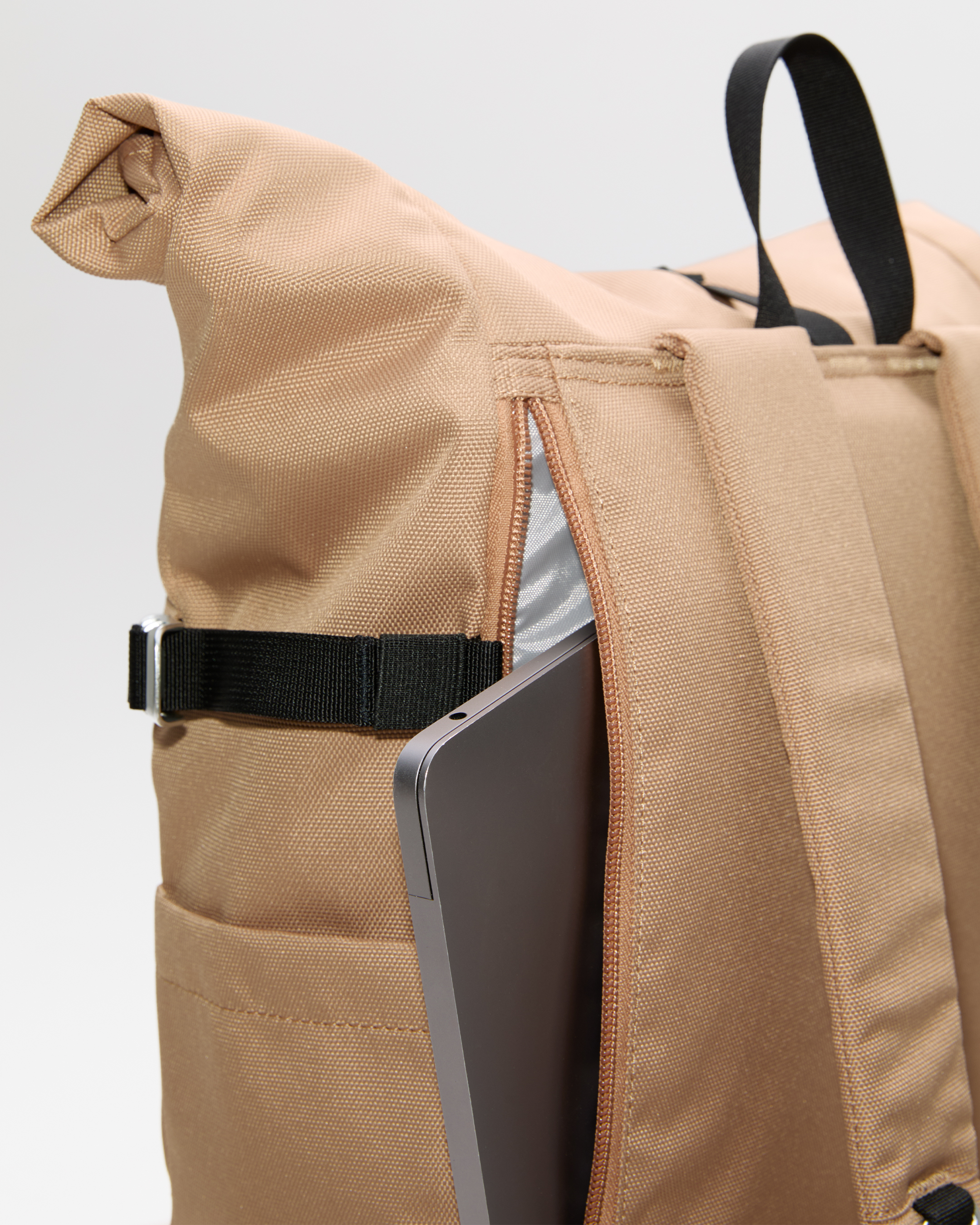 Sandqvist ICON Rolltop Backpack 14”, beige. Close-up of the outside laptop compartment with a zipper.