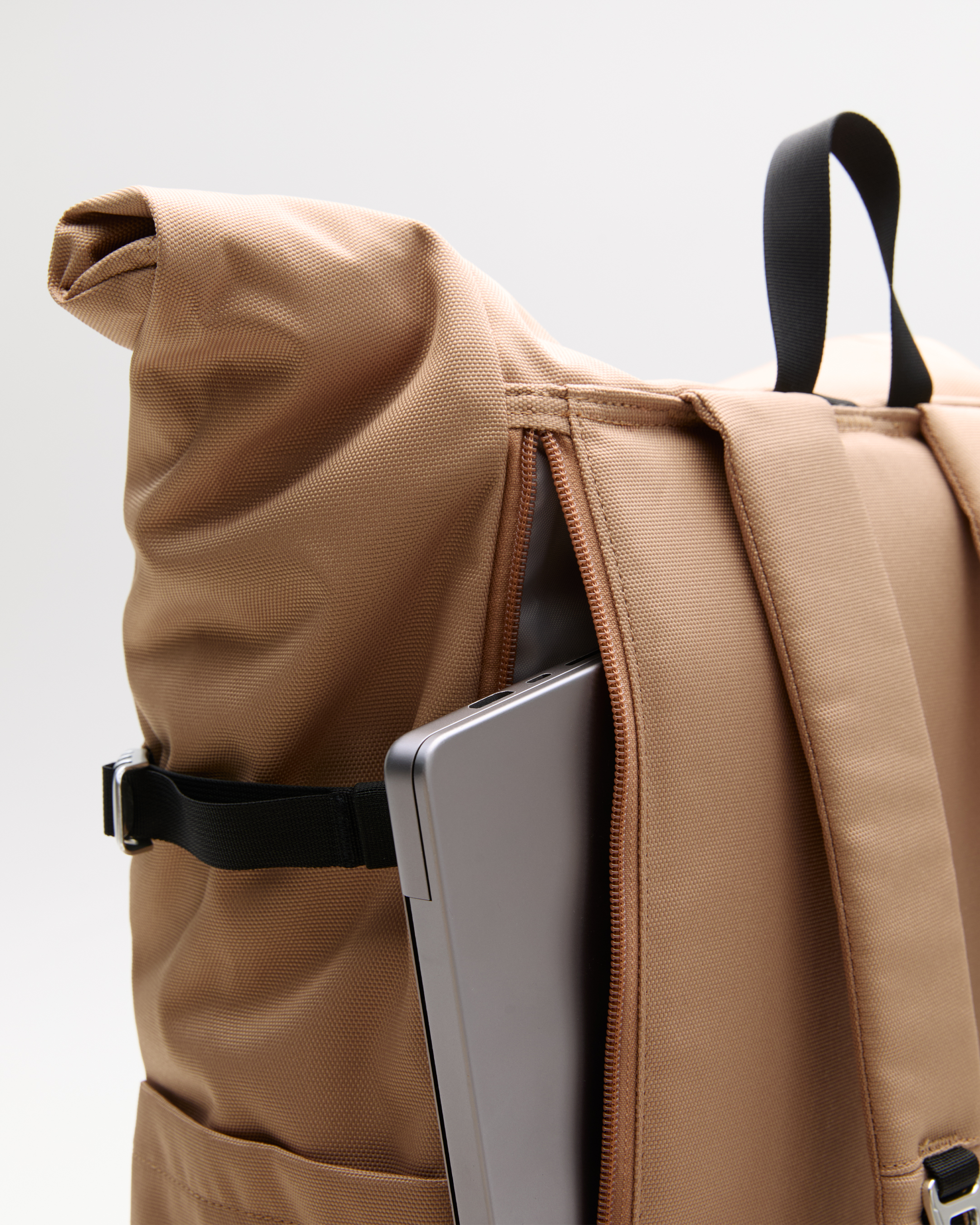 Sandqvist ICON Rolltop Backpack 16”, beige. Close-up of the outside laptop compartment with a zipper.