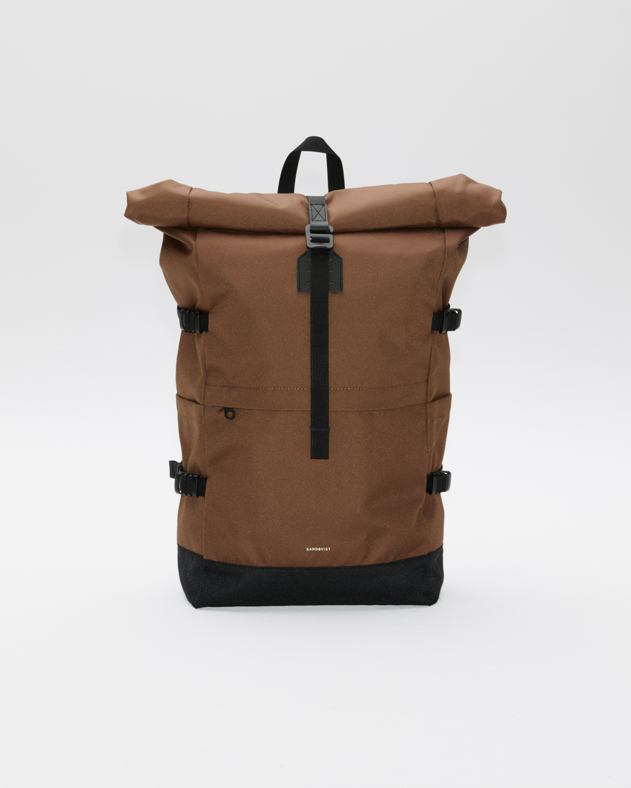 Sandqvist ICON Rolltop Backpack 16”, brown. Front view, showing rolltop closure with buckle, a top handle, two side straps on each side and a zippered front pocket.