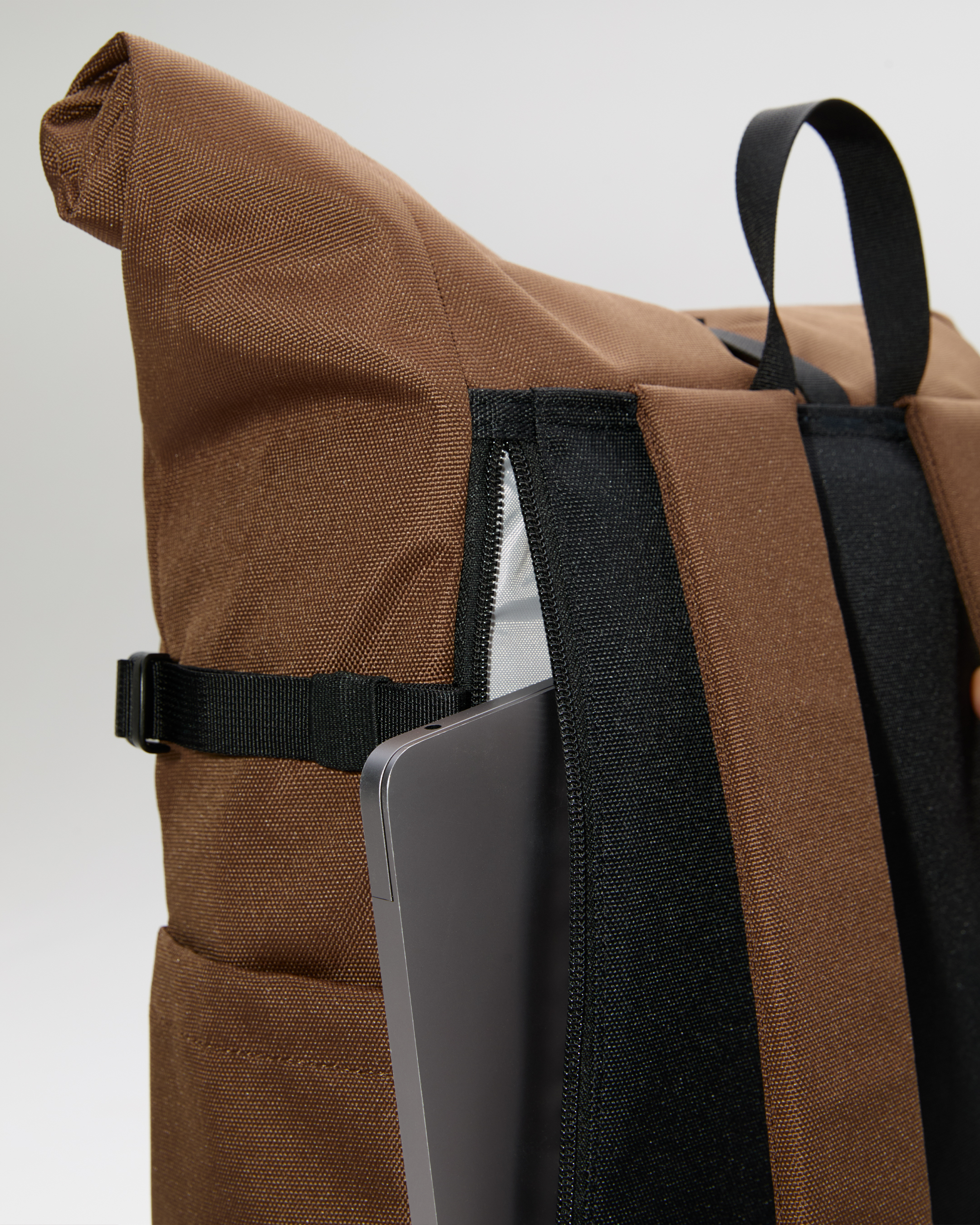 Sandqvist ICON Rolltop Backpack 14”, brown. Close-up of the outside laptop compartment with a zipper.