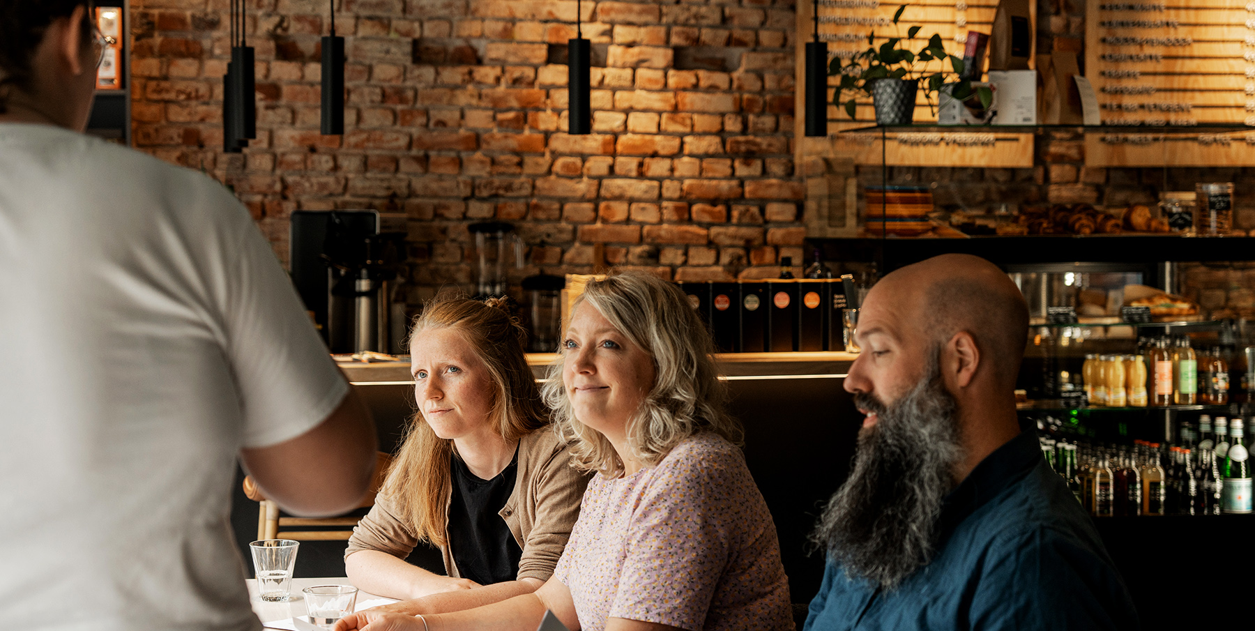 Coffee roaster speaking in front of three employees about coffee