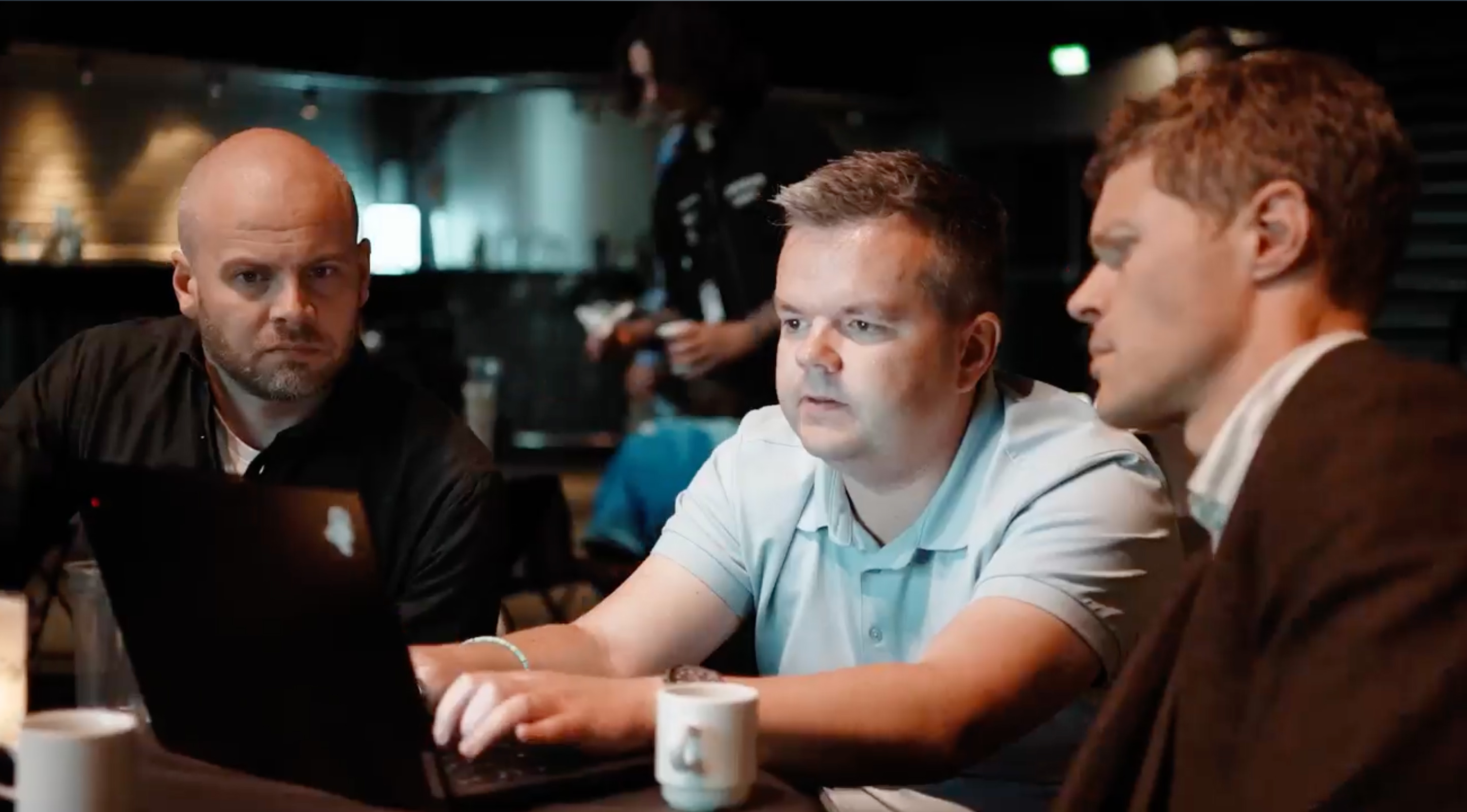 People sitting around a laptop at event