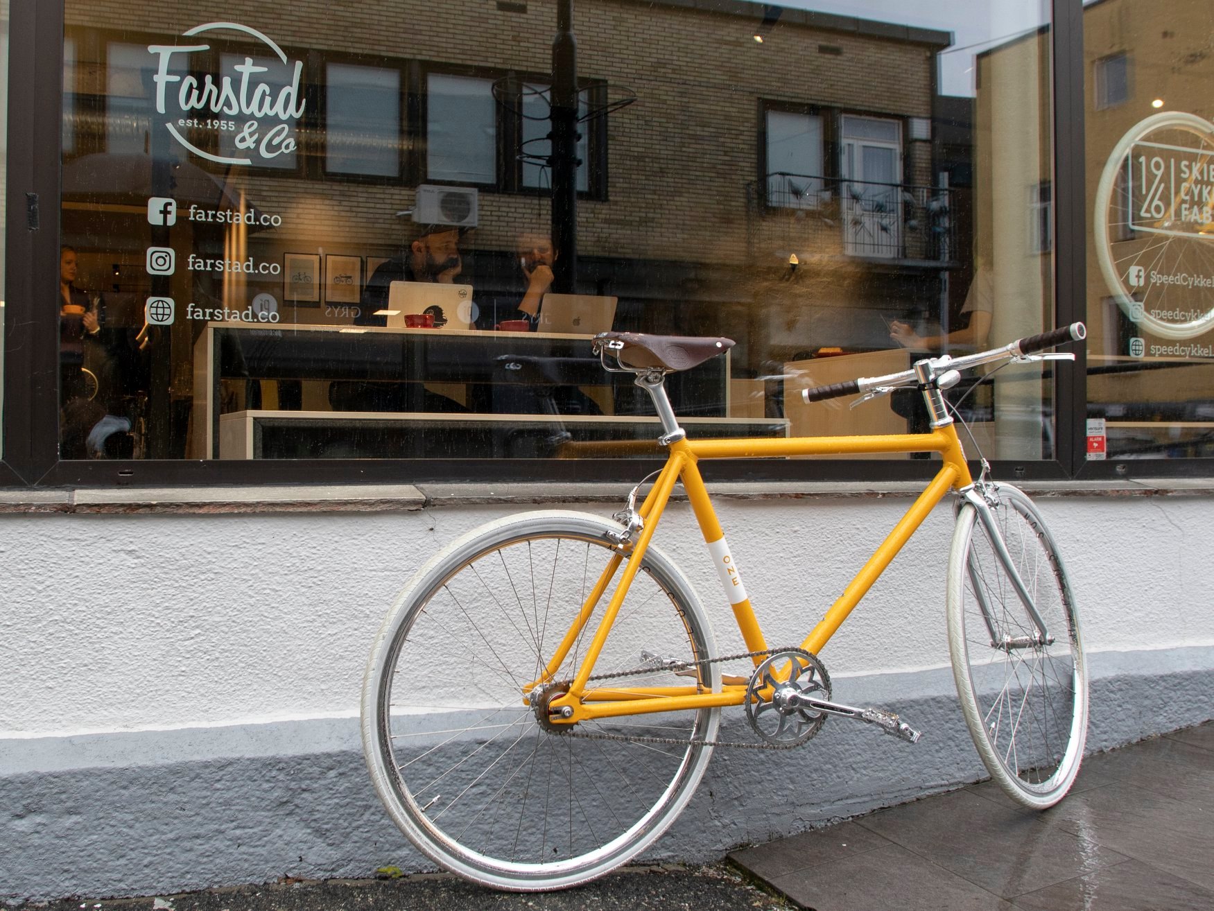 Bike in front of Farstad and co coffee shop with people working inside the café