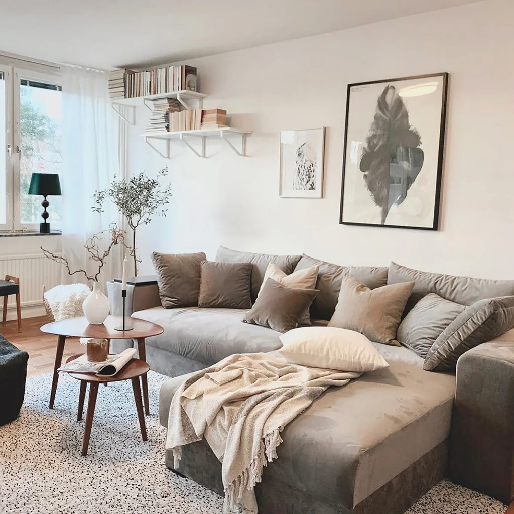 En praktisk sovesofa med divan, kledd i grå polyesterfløyel med oppbevaringsplass under setet og i armlenet.