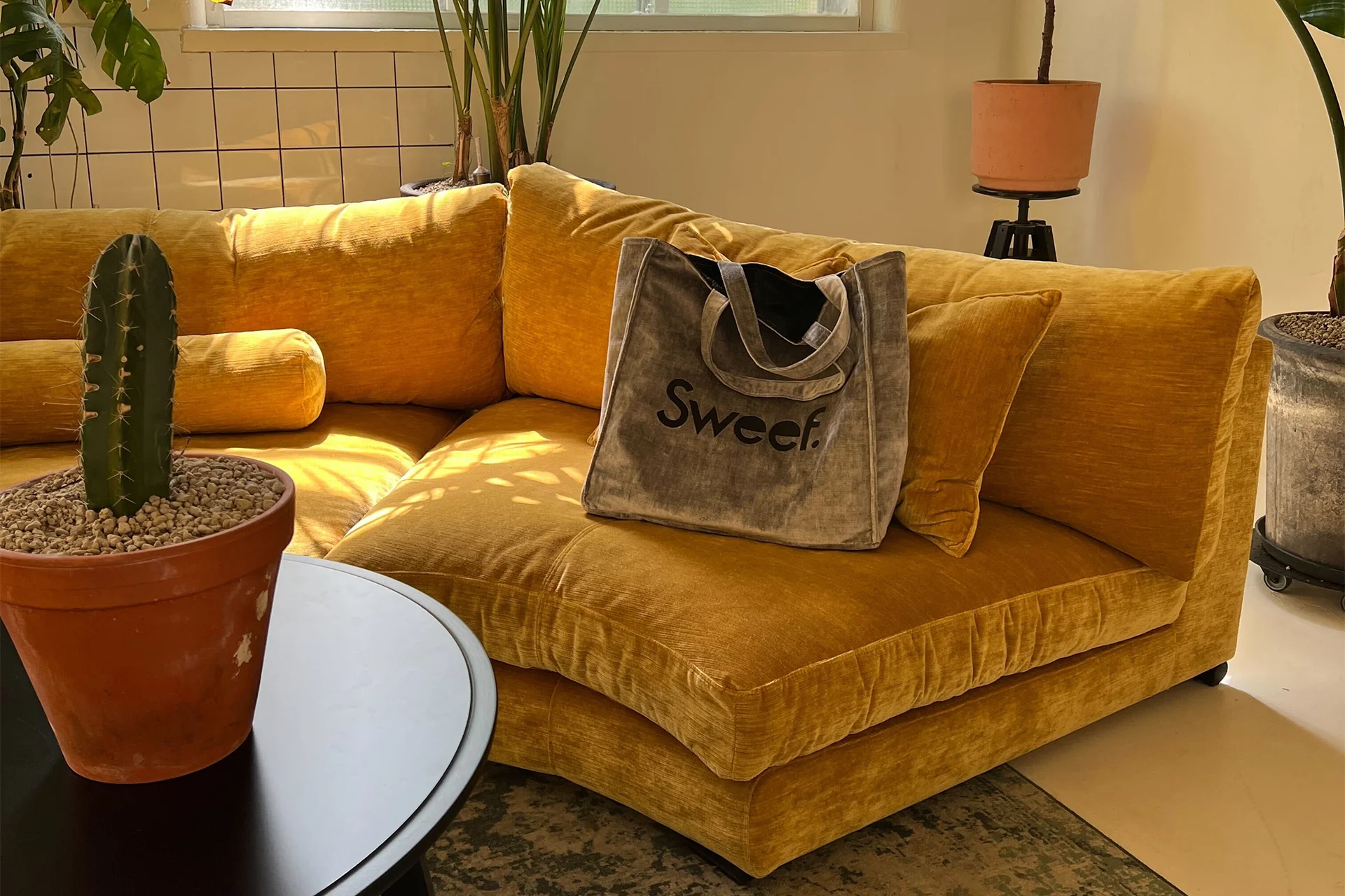 Svängd modulsoffa i ribbad, orange bomullssammet med sitt- och ryggkuddar i dun och kallskum.