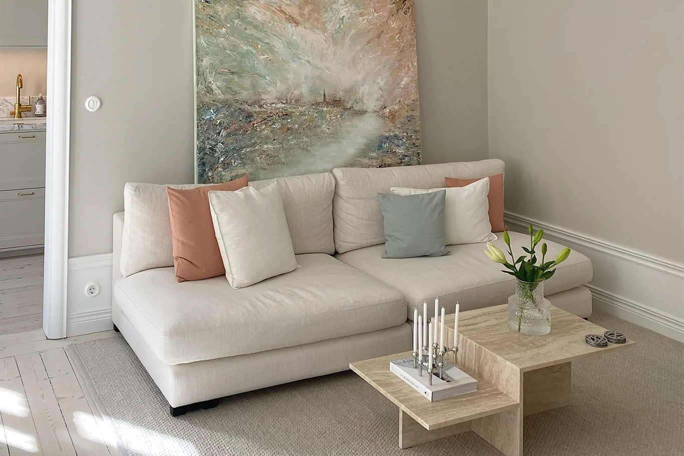 3-seters modulsofa uten armlener med sitteputer som er 113 cm dype og lave ryggputer, kledd i en hvit linblanding.
