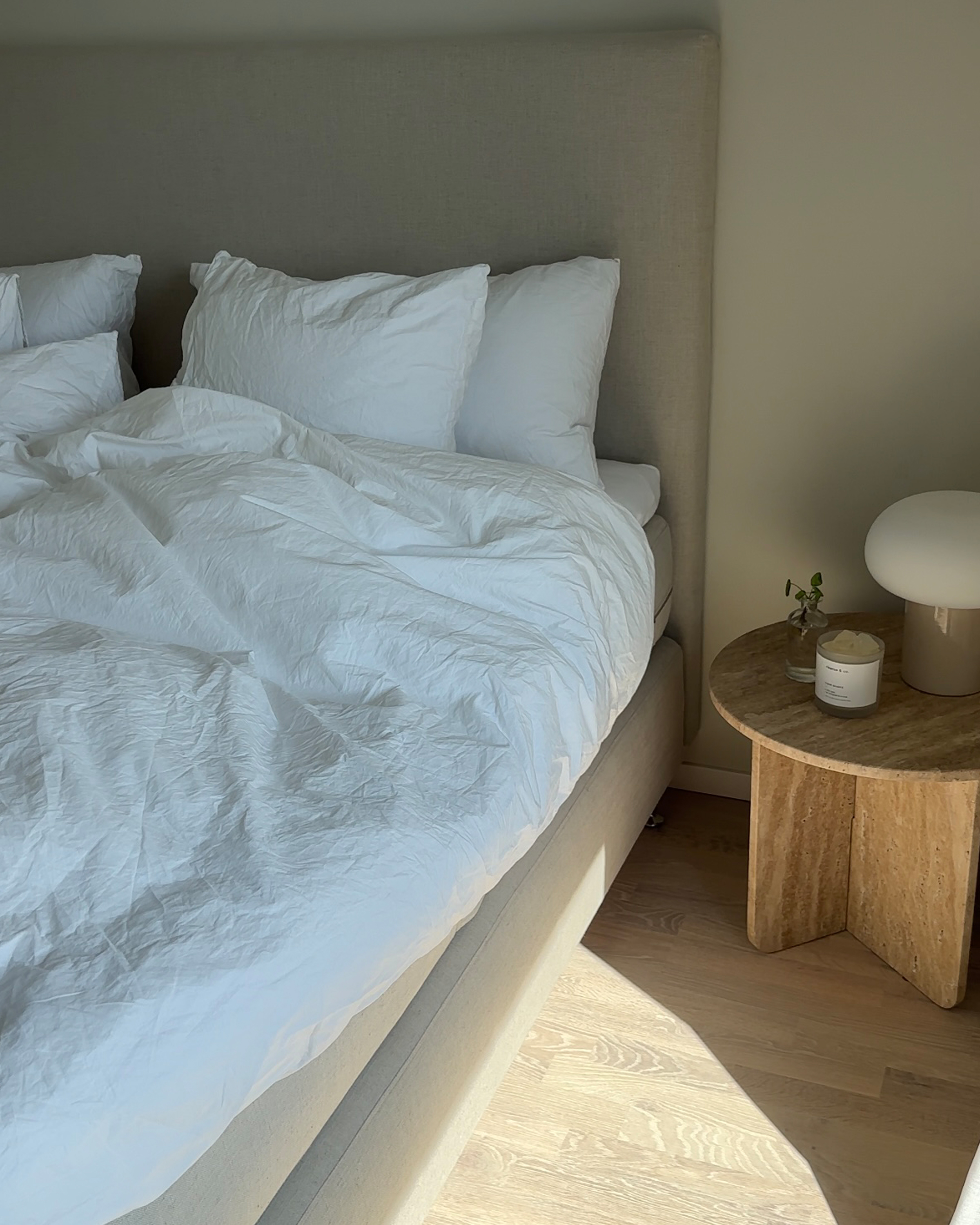 Zebran dobbeltseng med matchende glatt sengegavl i beige stoff.