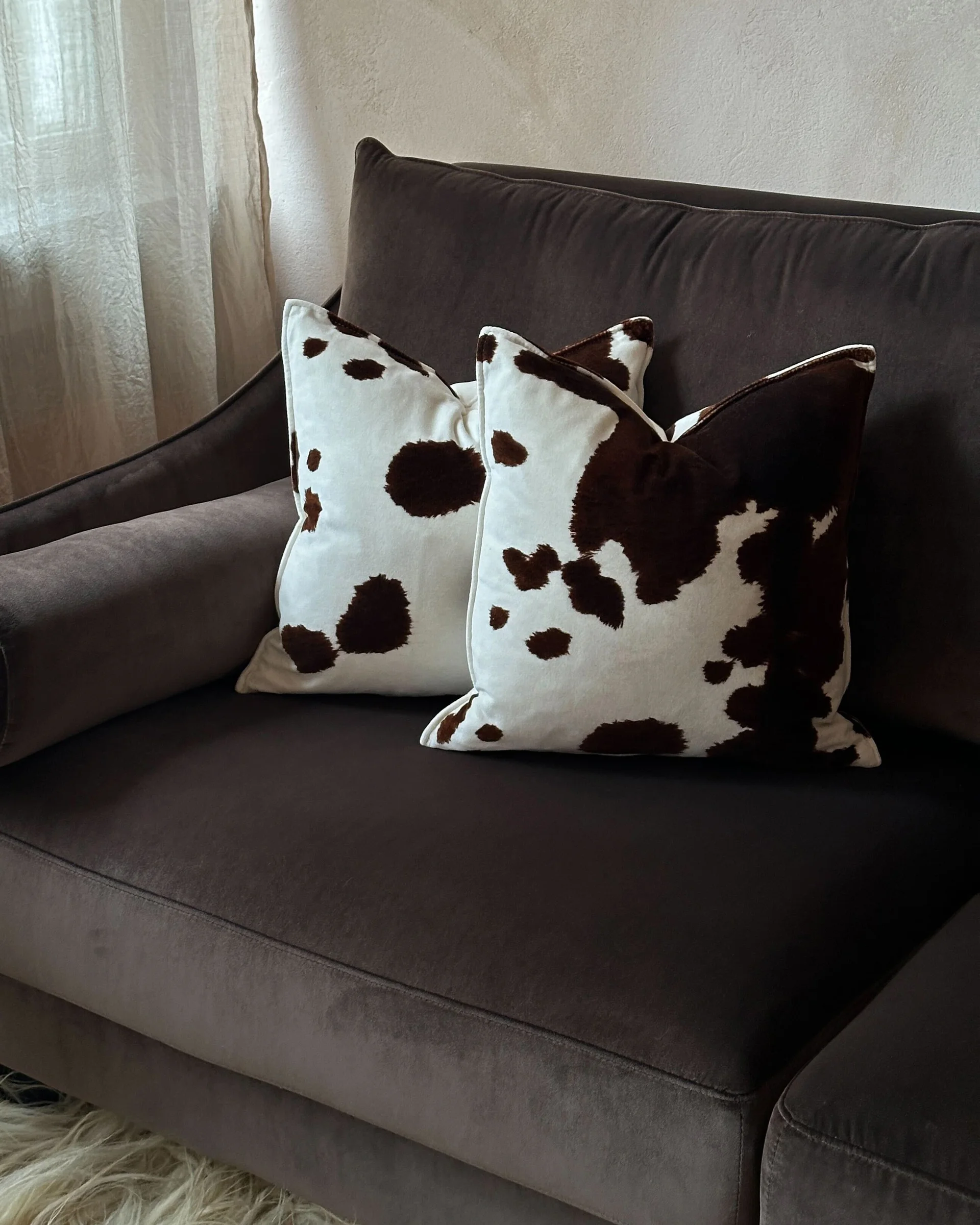 Nærbilde av armlene og sete på Antilopen brun fløyelssofa.