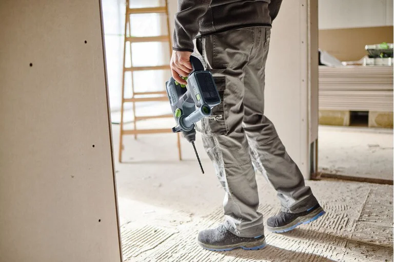 Montør bærer Festool KHC-S 18 over en byggeplass